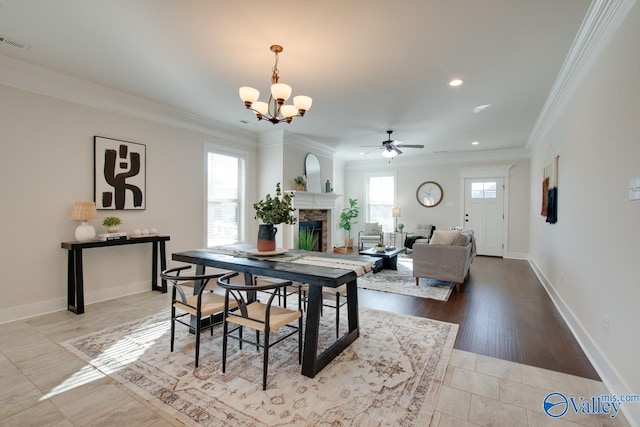 dining area featuring visible vents, a fireplace, baseboards, and ornamental molding