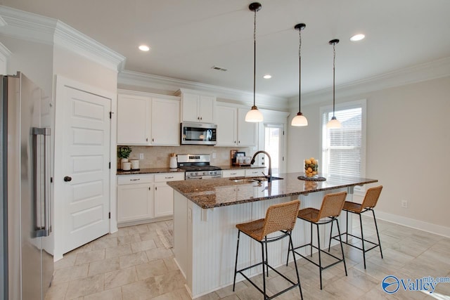 kitchen with visible vents, dark stone counters, appliances with stainless steel finishes, a sink, and backsplash