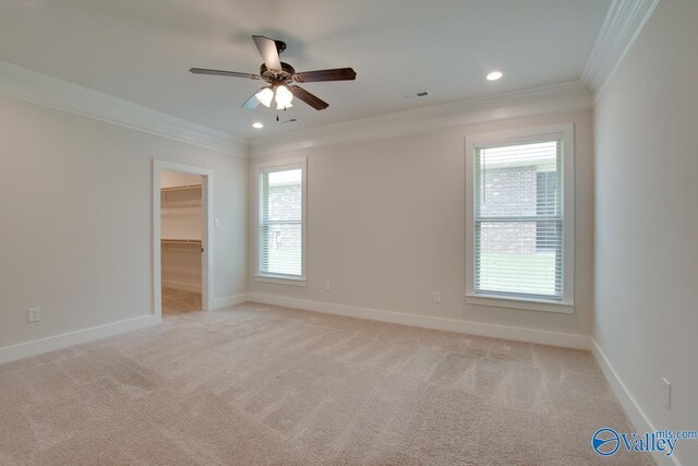 empty room with ornamental molding, light carpet, visible vents, and baseboards