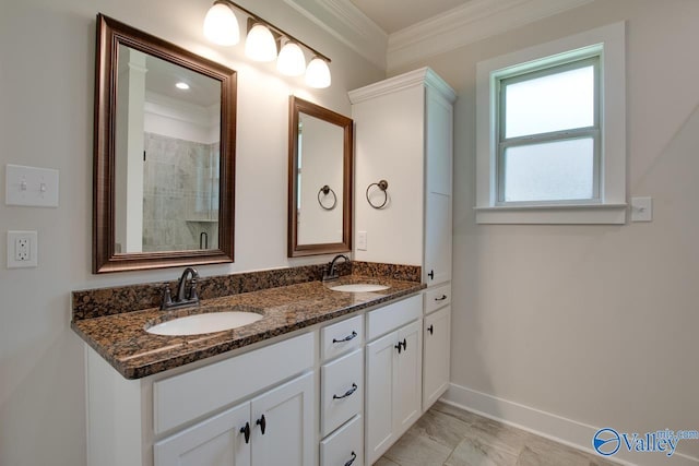 bathroom with ornamental molding, a sink, baseboards, and double vanity