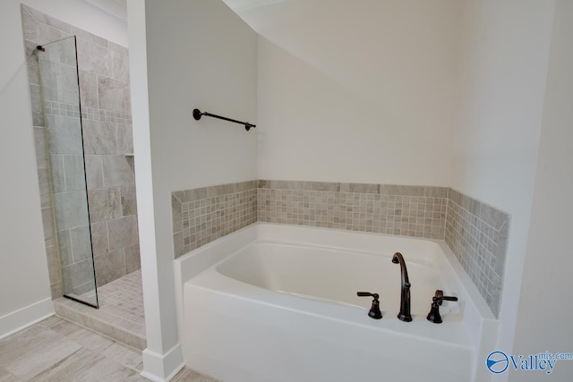 full bath featuring a garden tub and a tile shower