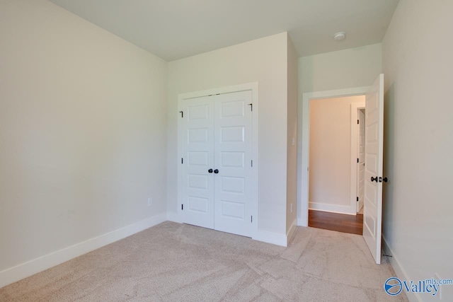 unfurnished bedroom featuring a closet, carpet, and baseboards