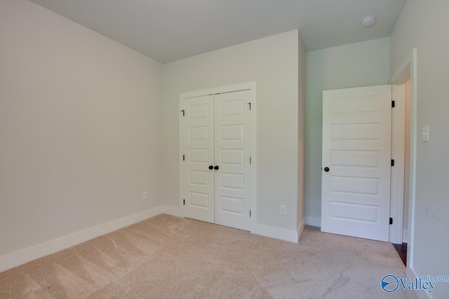 unfurnished bedroom featuring carpet floors, a closet, and baseboards