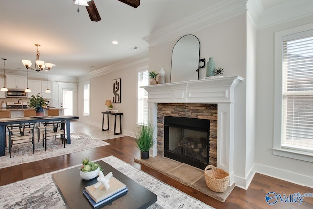 living room with dark wood-style flooring, crown molding, and baseboards