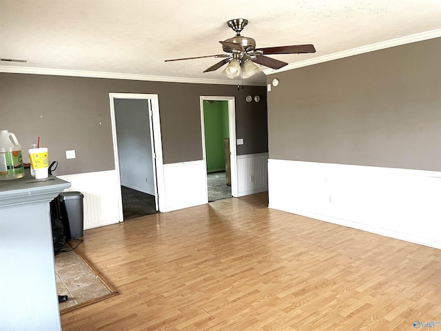 unfurnished living room with ceiling fan, ornamental molding, and light hardwood / wood-style floors