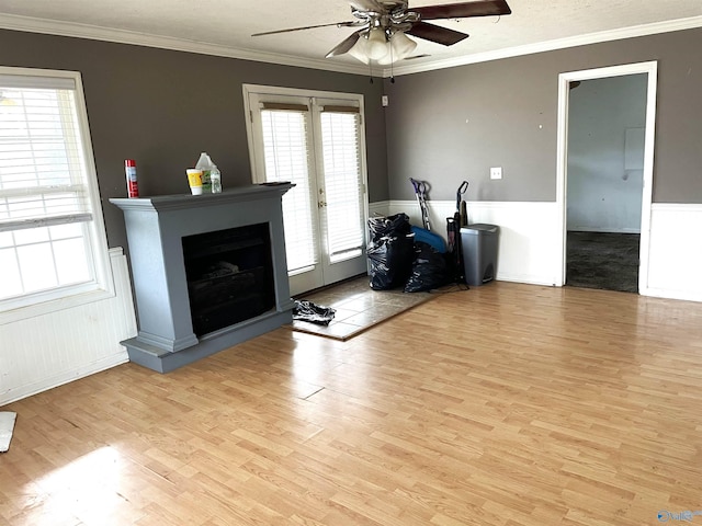 exercise room with french doors, a healthy amount of sunlight, crown molding, and light wood-type flooring