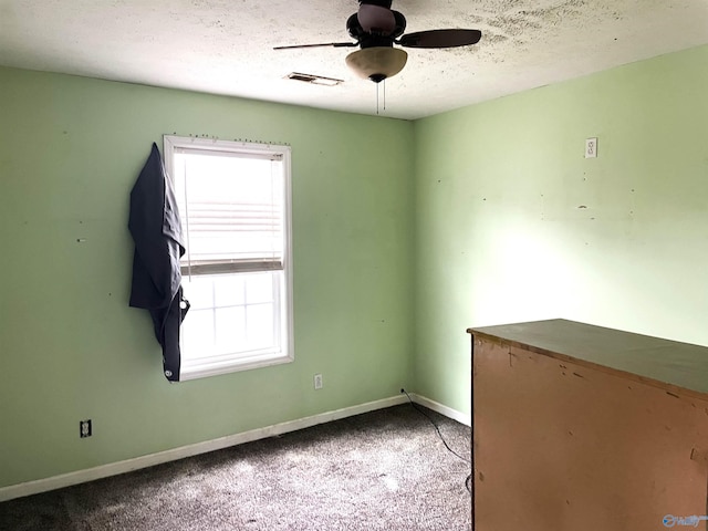 carpeted empty room featuring ceiling fan and a textured ceiling