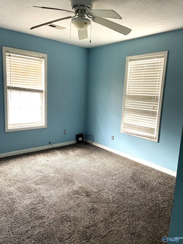 carpeted spare room featuring ceiling fan