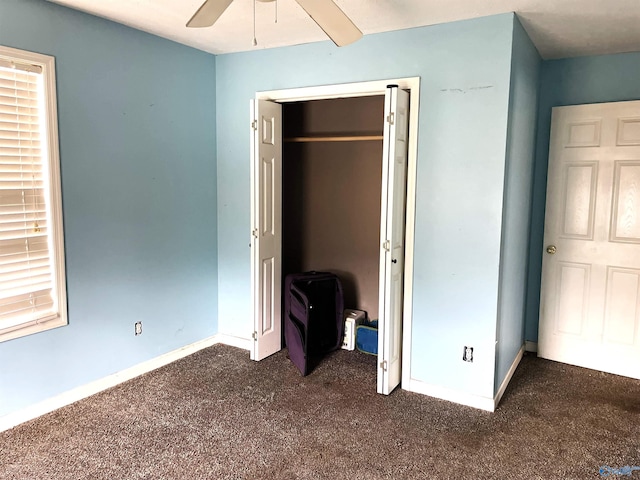 unfurnished bedroom featuring ceiling fan, dark carpet, and a closet