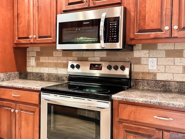 kitchen featuring brown cabinetry, appliances with stainless steel finishes, and tasteful backsplash