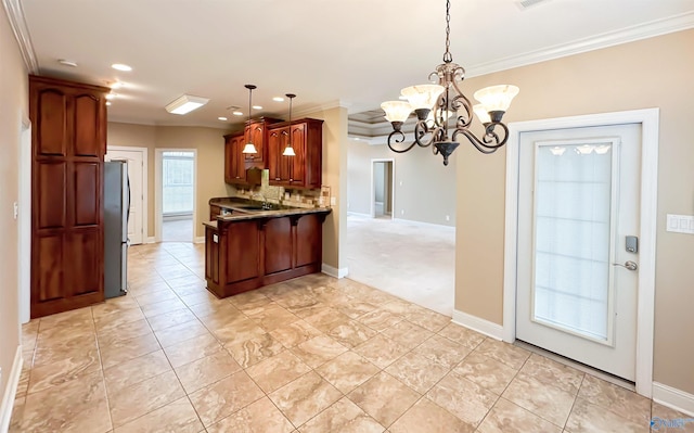 kitchen with backsplash, decorative light fixtures, ornamental molding, a peninsula, and freestanding refrigerator