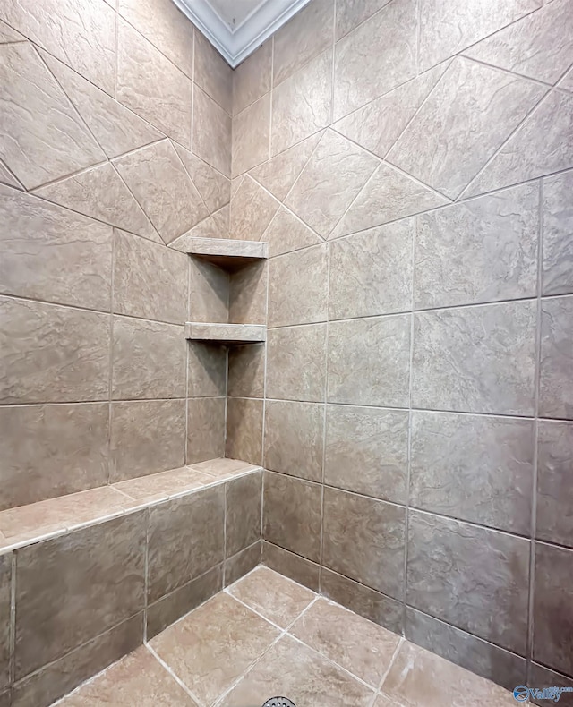 bathroom featuring crown molding and tiled shower