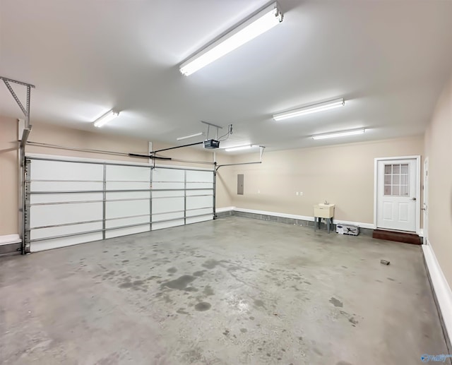 garage with electric panel, a garage door opener, and baseboards