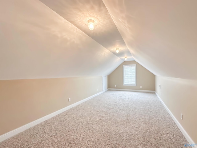 bonus room featuring light carpet, baseboards, and vaulted ceiling