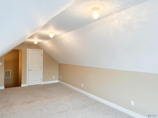 additional living space with visible vents, carpet flooring, baseboards, and vaulted ceiling