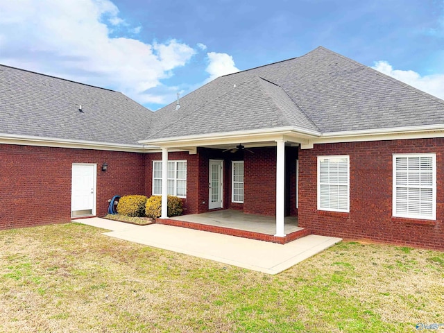 back of property with brick siding, a shingled roof, a yard, a patio area, and a ceiling fan