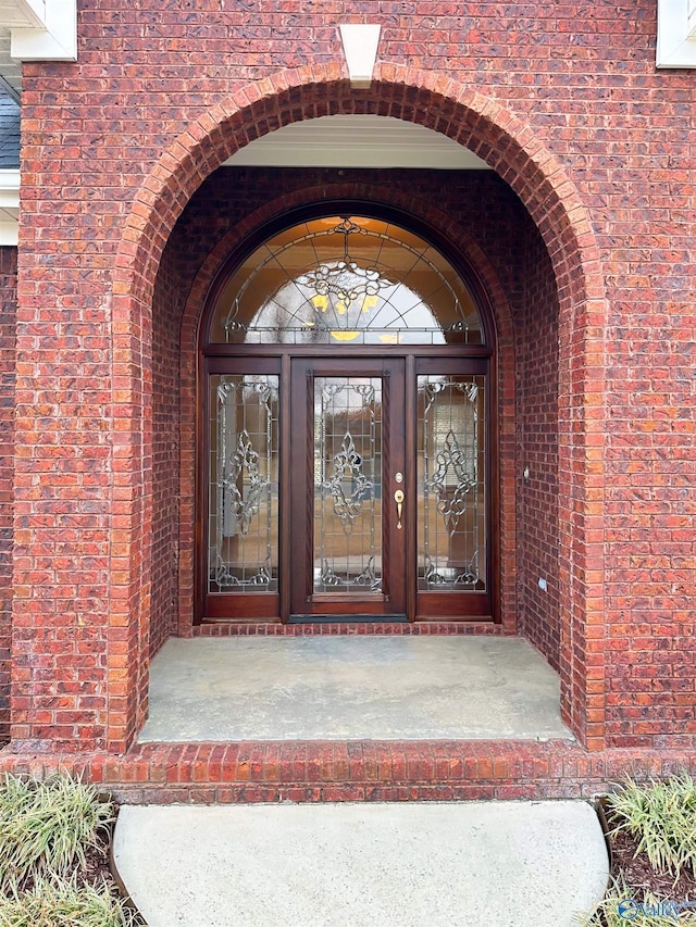 entrance to property featuring brick siding