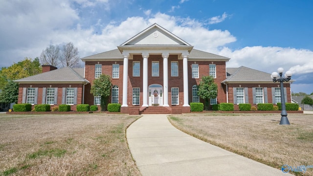 greek revival inspired property with a front yard