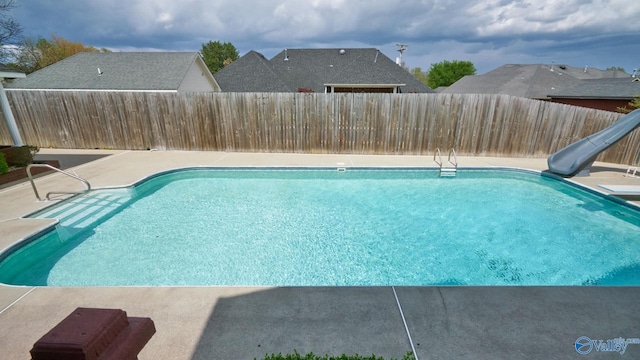 view of pool featuring a water slide and a patio area