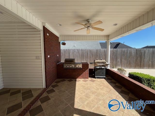 view of patio / terrace featuring a grill, fence, an outdoor kitchen, and a ceiling fan