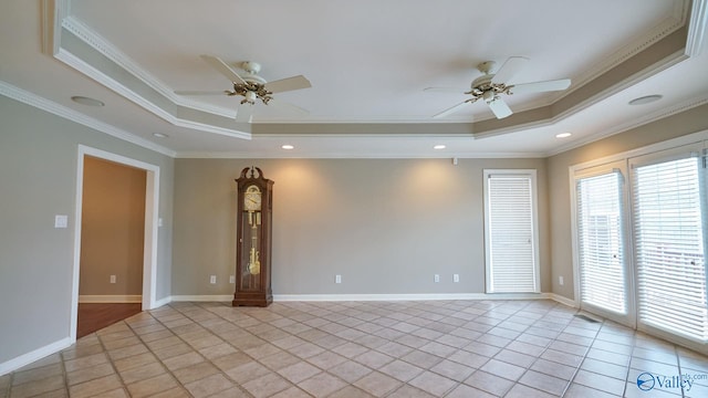 tiled empty room featuring ceiling fan, ornamental molding, and a tray ceiling