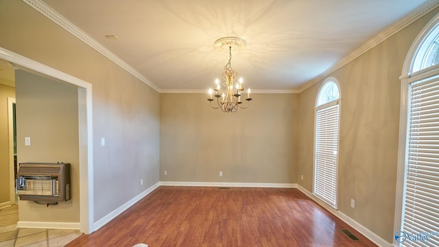 empty room with a notable chandelier, wood finished floors, heating unit, baseboards, and ornamental molding