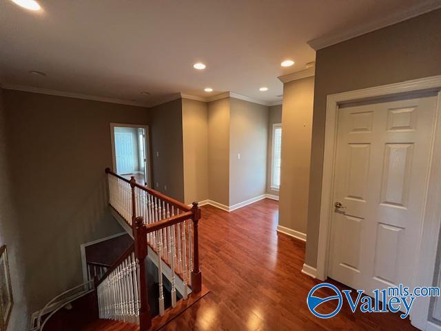 hall featuring baseboards, recessed lighting, an upstairs landing, wood finished floors, and ornamental molding