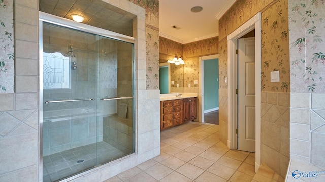 bathroom with tile patterned floors, a shower with door, vanity, and ornamental molding