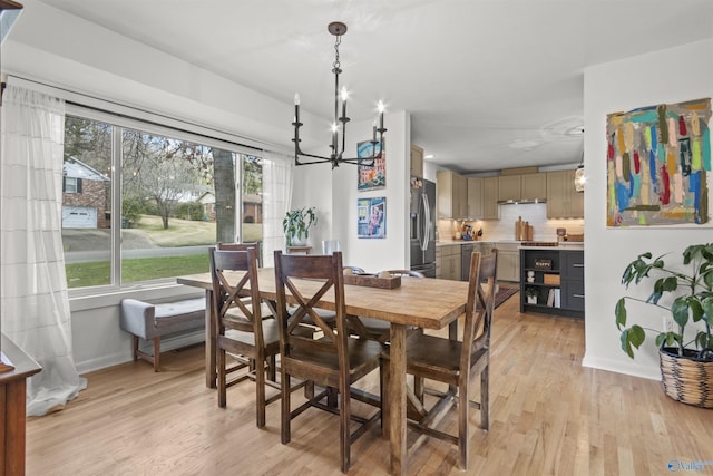 dining space featuring light hardwood / wood-style flooring and an inviting chandelier