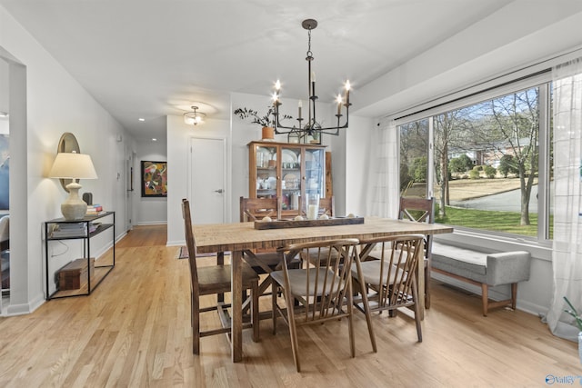 dining space featuring an inviting chandelier and light hardwood / wood-style flooring