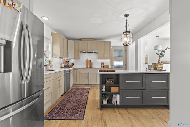 kitchen featuring appliances with stainless steel finishes, light wood-type flooring, backsplash, gray cabinetry, and pendant lighting