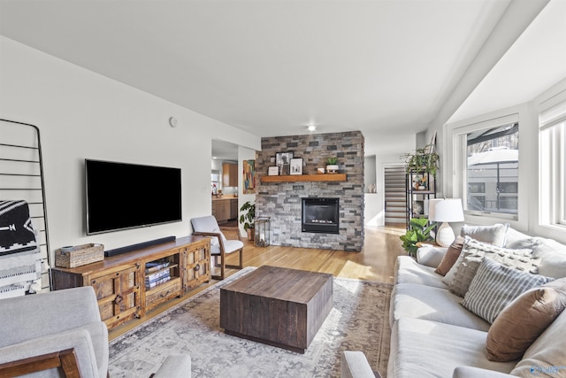 living room featuring light hardwood / wood-style flooring and a stone fireplace