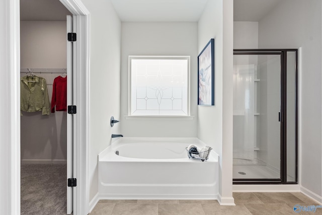20593 Brook Valley Dr, Athens, AL 35611 - bathroom featuring a stall shower, a bath, baseboards, and a spacious closet