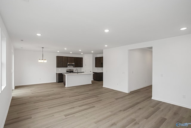 unfurnished living room featuring sink and light wood-type flooring