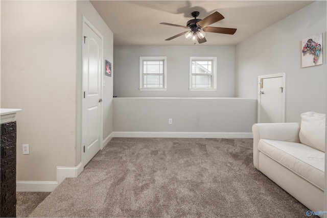 living area with ceiling fan, baseboards, and carpet flooring