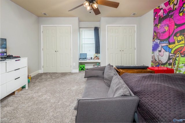 carpeted living room with a ceiling fan, visible vents, and baseboards