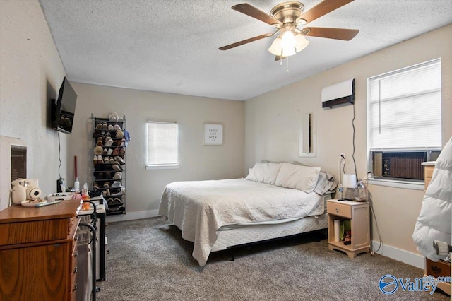 carpeted bedroom with ceiling fan, a textured ceiling, and a wall mounted AC