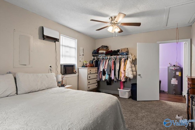 carpeted bedroom with electric water heater, ceiling fan, a textured ceiling, a wall mounted AC, and a closet