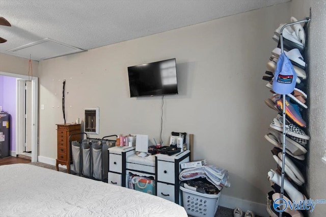 bedroom with a textured ceiling and water heater