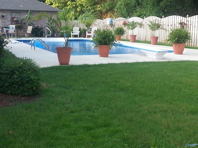 view of pool with a patio, a diving board, and a lawn