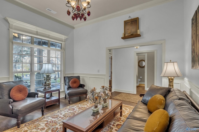 living room with an inviting chandelier, hardwood / wood-style flooring, and ornamental molding