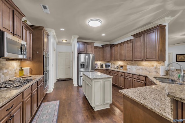 kitchen with stainless steel appliances, a kitchen island, dark hardwood / wood-style flooring, light stone countertops, and sink