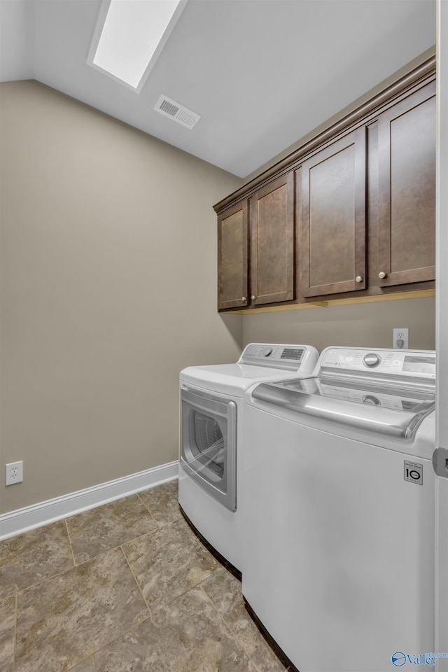 clothes washing area with cabinets and washer and dryer