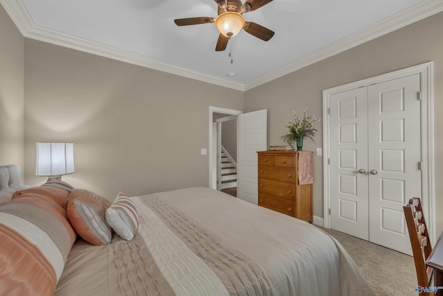 bedroom with ceiling fan, a closet, crown molding, and carpet