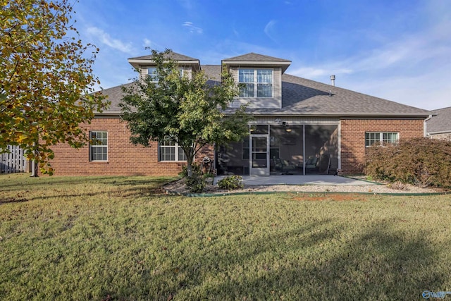 rear view of house featuring a sunroom, a yard, and a patio area