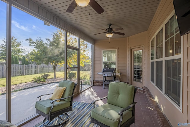 sunroom featuring wood ceiling and ceiling fan