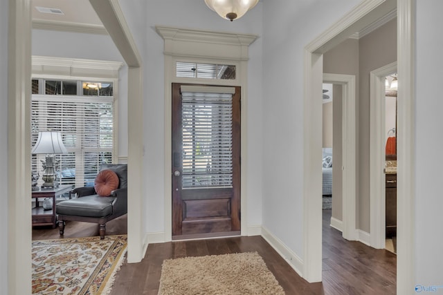 entrance foyer with dark hardwood / wood-style flooring and ornamental molding