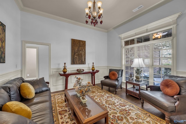 living room featuring a chandelier, hardwood / wood-style flooring, and ornamental molding