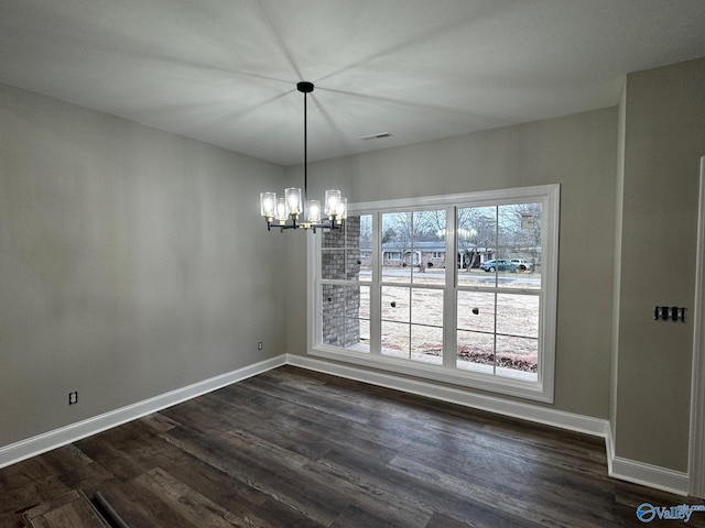 unfurnished dining area featuring a chandelier and dark hardwood / wood-style flooring