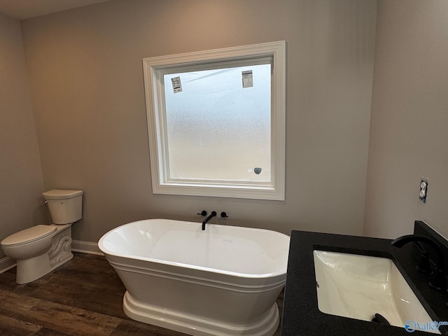 bathroom with sink, toilet, a bath, and wood-type flooring